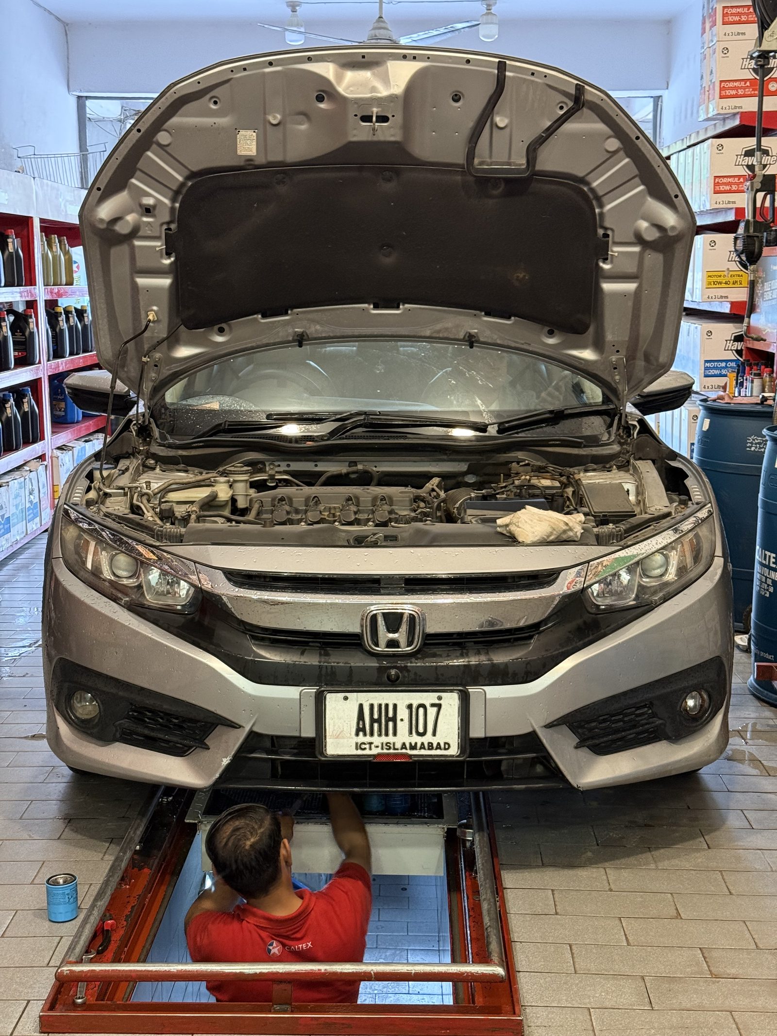 Technician performing an express oil change on a Honda Civic at Lubri Care Xpress